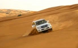 Dune buggy riding across golden desert dunes